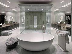 a large white bath tub sitting inside of a bathroom next to a walk in shower