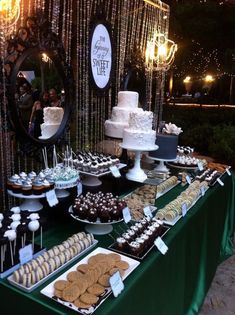 a table topped with lots of desserts next to a cake and cupcake display