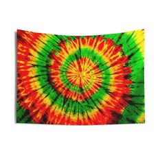 a multicolored tie - dyed tapestry hanging on a wall in front of a white background