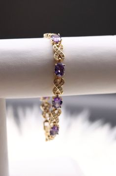 The Purple Gemstones Infinity Bracelet gracefully intertwines the symbolism of infinity with the allure of rich purple gemstones, creating a captivating and meaningful accessory. This bracelet adds a touch of royal elegance to your ensemble while conveying a sense of eternal beauty. Amethyst Bracelet Gemstones, Elegant Infinity Gemstone Jewelry, Elegant Purple Bracelets For Wedding, Elegant Purple Wedding Bracelets, Elegant Amethyst Bracelets For Wedding, Elegant Amethyst Gemstone Bracelets, Elegant Amethyst Bracelets With Gemstone Accents, Elegant Purple Gemstone Bracelets, Purple Cubic Zirconia Bracelets For Anniversary