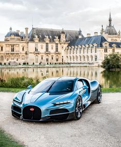 a blue bugatti is parked in front of a castle