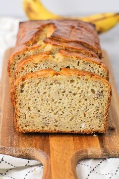 sliced loaf of banana bread sitting on top of a wooden cutting board