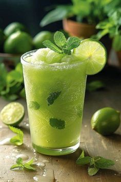 a green drink with limes and mint on the side