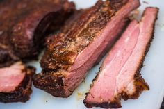 some meat is sitting on a white plate and ready to be cut into pieces or put in the oven