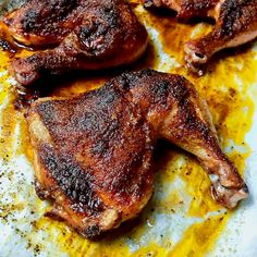 two pieces of meat sitting on top of a pan covered in oil and seasoning