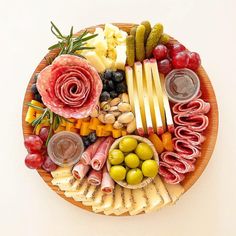 a platter filled with meats, cheeses, olives and other foods