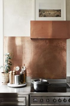 a stove top oven sitting inside of a kitchen next to a pot on the counter