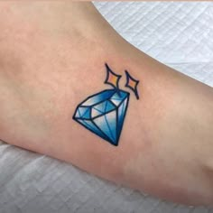 a small blue diamond tattoo on the foot