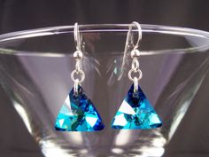 "Relive your favorite beach vacation every time you wear Bermuda Blue crystals! Sparkling prisms of ocean blue-green triangles hang beneath sterling silver ear hooks. These fine crystal 16mm triangles are just the right size for earrings with a drop length of only 0.75 inches and a total length of 1.25 inches (32mm). A small and lightweight dangle earring, in a bold easily seen turquoise blue color. The matching pendant can be found at https://www.etsy.com/listing/549086325 Fast free USPS domest Bohemian Blue Triangle Earrings, Blue Dangle Crystal Earrings With Faceted Beads, Blue Bohemian Triangle Earrings, Modern Geometric Jewelry, Nickel-free Blue Teardrop Crystal Earrings, Elegant Turquoise Nickel-free Crystal Earrings, Turquoise Blue Color, Blue Crystal Earrings, Teal Turquoise