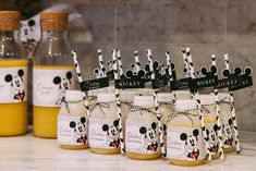 there are many bottles with mickey mouse labels on them and tags in front of them