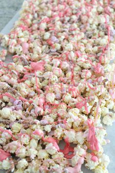 popcorn covered in pink and white sprinkles sitting on top of a table