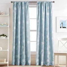 the curtains in this room are blue with white flowers on them and one window is closed