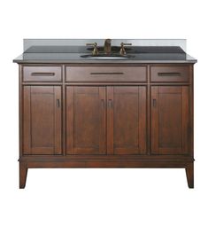 a bathroom vanity with marble top and two faucets on the sink area,