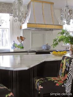 a kitchen with an island and chandelier hanging from it's ceiling over the stove