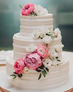 a white wedding cake with pink and white flowers