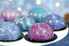 some kind of colorful cake sitting on top of a white plate with blue and purple icing