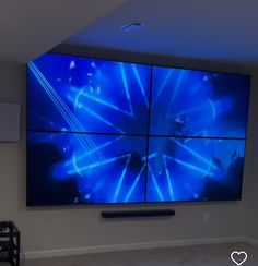 a large screen in the corner of a room with white walls and blue lights on it