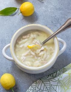 a white bowl filled with soup next to lemons