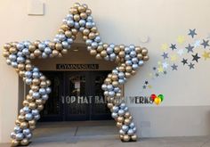 a large star made out of balloons in front of a building with stars on the wall