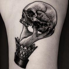 a black and white image of a human skull holding a flower in it's hand