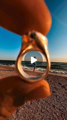 a person holding a magnifying glass looking at the ocean