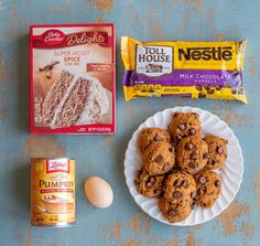 chocolate chip cookies, milk and eggs on a blue table with an assortment of ingredients