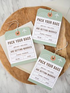 three luggage tags on a wooden tray with some paper attached to the tags that say, pack your bags are getting married