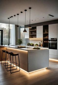 a modern kitchen with an island and bar stools in the center, lighted by lights