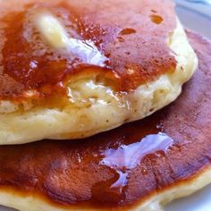 two pancakes covered in syrup on a white plate