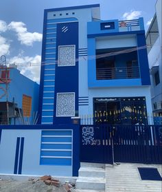 a blue and white building with an iron fence around it