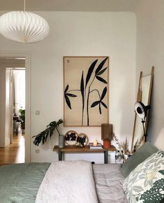 a bed sitting in a bedroom next to a painting