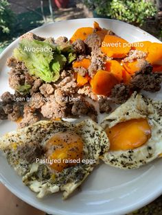 a white plate topped with eggs, meat and veggies on top of it