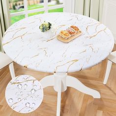 there is a white table with gold leaf designs on it and a small tray of food sitting on top