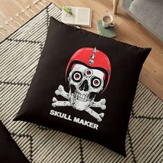 a skull wearing a red helmet with the words skull maker on it floor pillow sitting on top of a rug