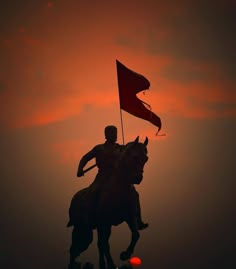 a statue of a man riding on the back of a horse holding a red flag