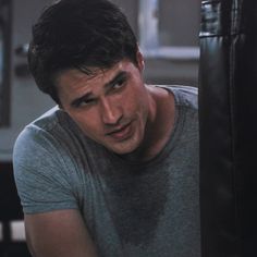 a man leaning against a punching bag in a gym