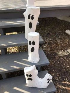 three white vases with black spots on them sitting on some concrete steps in front of a house