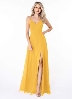 a woman in a yellow long dress posing for the camera with her legs slited