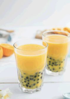 two glasses filled with orange juice on top of a table