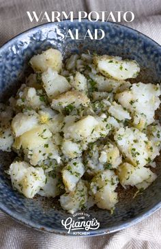 a blue bowl filled with potatoes and herbs