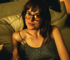 a woman wearing glasses sitting on a couch