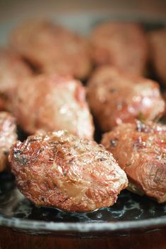 some meatballs are sitting on a black plate