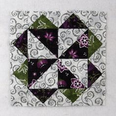 a quilted square with purple and green flowers on it