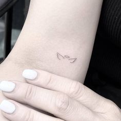 a woman's arm with a small tattoo on it