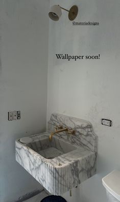 a bathroom with a marble sink and toilet in the corner that says wallpaper soon