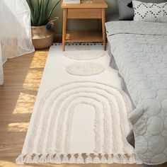 a bedroom with a white rug on the floor next to a wooden table and bed