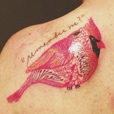 a woman's breast with a pink bird tattoo on her chest and words written in cursive writing