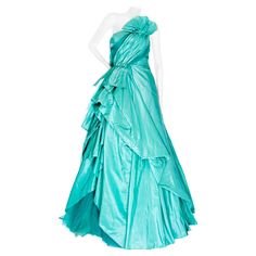 Oscar de la Renta 2013 Turquoise Blue Taffeta and Tulle Strapless Gown Resort Collection at Moda Nextel (Mexico) Aqua Blue / Turquoise One shoulder Ruched bodice Fan detail Side draping with inset tulle Gathered back Pointed train Tulle lining Boned bustier Back zipper closure Made in USA 100% silk Very good preowned unworn condition; side draping detached in a couple areas and some broken stitches on bodice Size & Measurements Approximate, taken flat: US 8 May run small; please refer to measurements Bust: 14.5" Waist: 13.5" Back Center Length: 56" Mannequin is an approximate US Size 4; garment was clipped for photos. Strapless Gown, Ruched Bodice, Bleu Turquoise, Resort Collection, Blue Turquoise, Turquoise Blue, Aqua Blue, Bodice, Evening Dresses