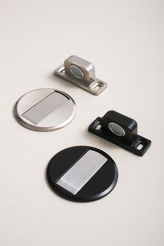 three different types of metal buttons on a white surface with one button facing the camera