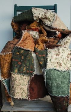 an old chair covered in blankets and pillows